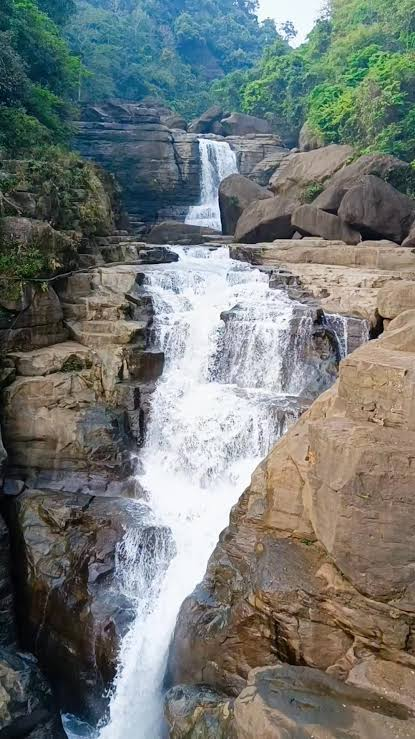 Chaparai waterfall cascading over layered rock in the forest